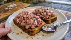 Crudo valdiviano en pan tostado: carne de res con limón y salsa cremosa