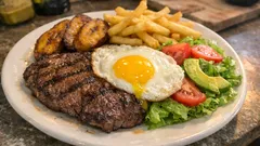 Churrasco a lo pobre: carne bien sellada con plátano frito, huevo y papas crujientes
