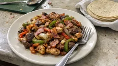 Alambre mixto en un solo sartén: res, pollo, tocino y pimientos bien doraditos