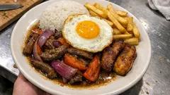 Lomo saltado a lo pobre: salteado jugoso con papas fritas, plátano macho y huevo